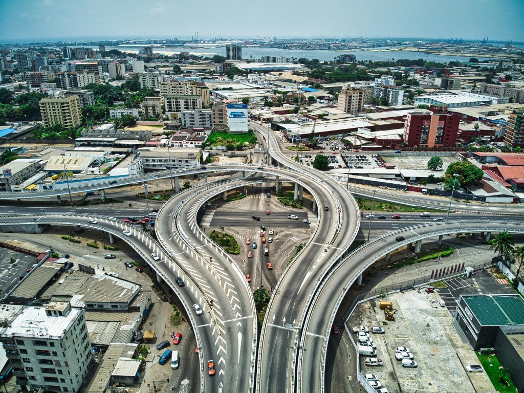 A vibrant aerial view showcasing the bustling expressways and urban landscape of Abidjan, Côte d'Ivoire.